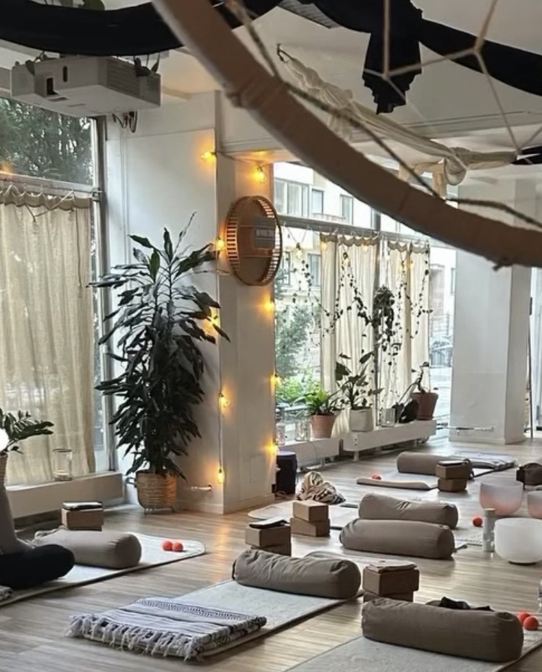 Rauhallinen joogastudio, jossa matot ja bolsterit odottavat yin-joogaryhmää